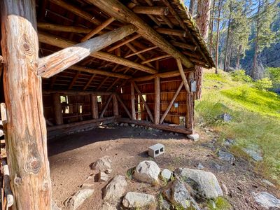 Interior and front of the three-sided shelter with an earthen floor