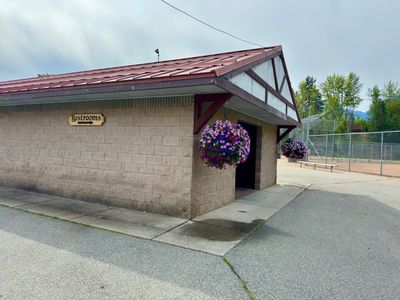 Restrooms building with hanging flower baskets at Enchantment Park